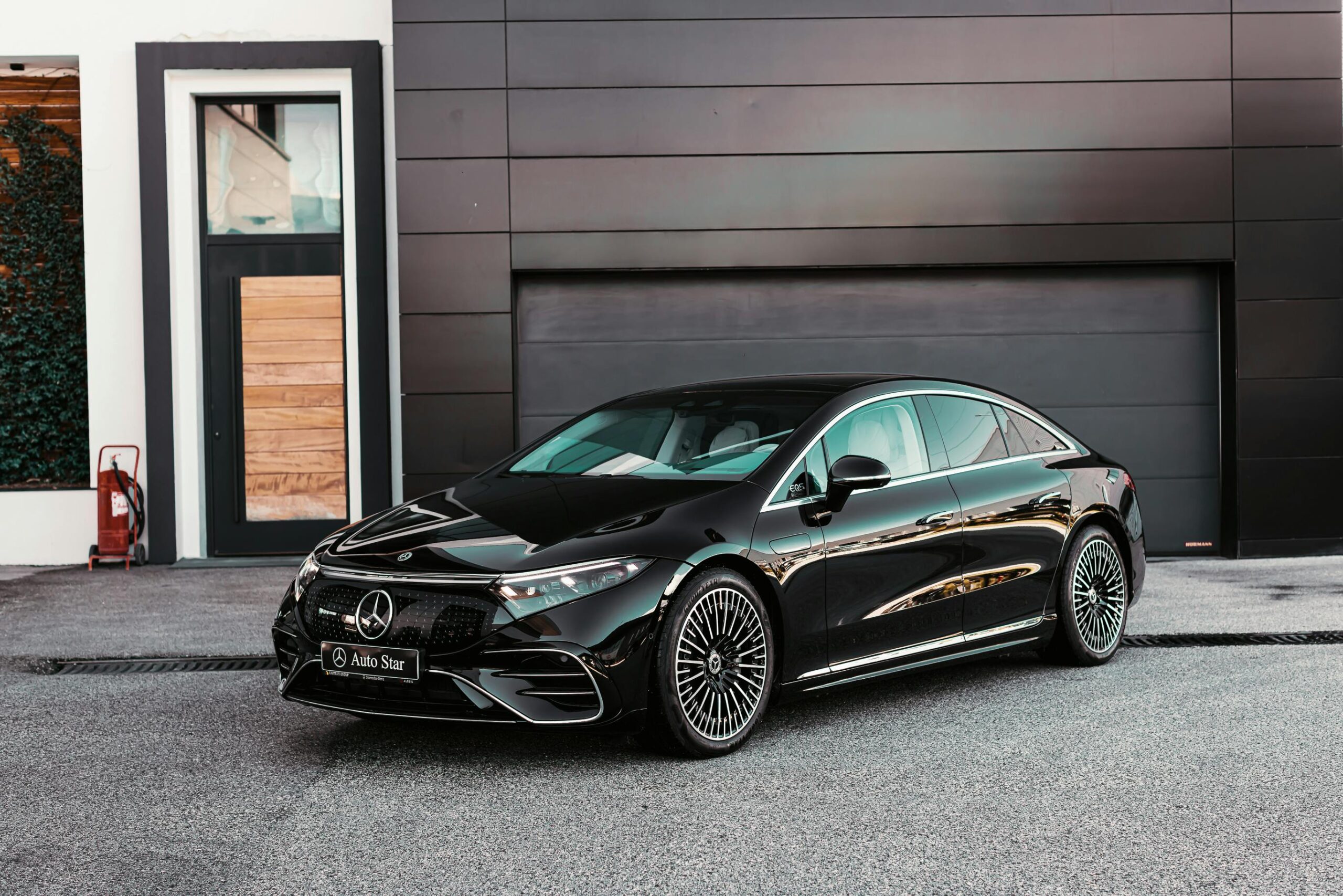 Sleek black Mercedes-Benz sedan parked in front of a modern building in Tirana, Albania.