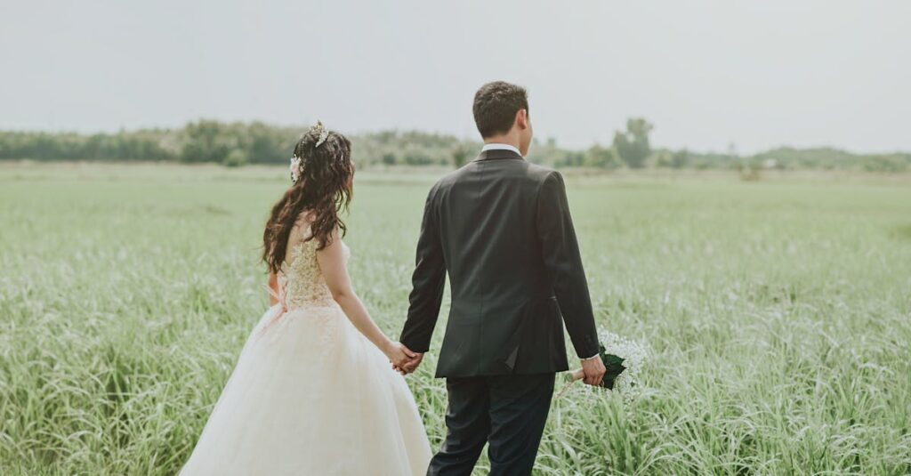 Couple holding hands in a serene field, perfect wedding photoshoot moment.
